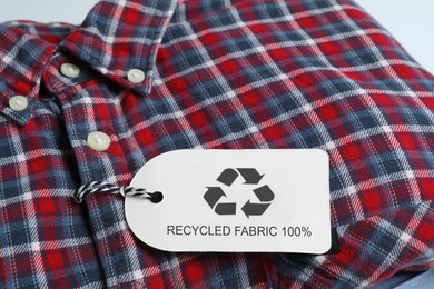 Photo of Checkered shirt with recycling label, closeup view