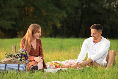 Young man and his girlfriend having picnic in park