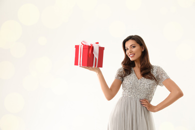 Beautiful woman with Christmas gift on white background