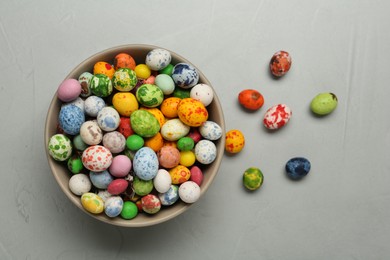 Ceramic bowl with delicious candies on grey table, flat lay. Cooking utensil