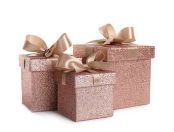 Shiny gift boxes with golden bows on white background