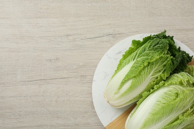 Fresh ripe Chinese cabbages on white wooden table, top view. Space for text