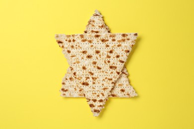 Star of David made with passover matzos on yellow background, top view