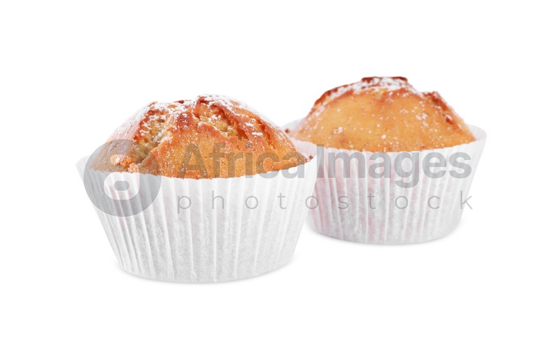 Photo of Tasty muffins powdered with sugar on white background