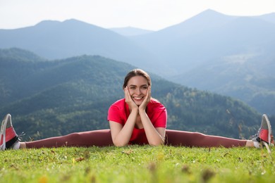 Photo of Young woman doing morning exercise in mountains