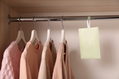 Scented sachet and clothes hanging in wardrobe