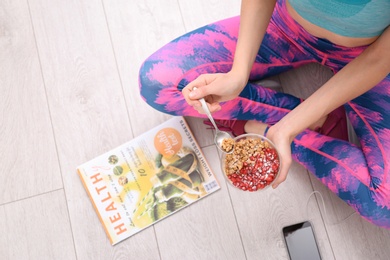 Young woman in fitness clothes having healthy breakfast at home, top view