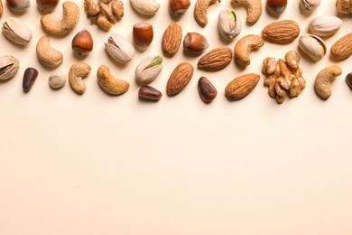 Photo of Flat lay composition with organic mixed nuts and space for text on color background