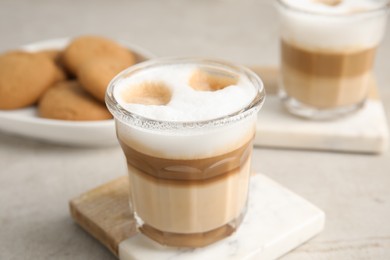 Glasses with delicious latte macchiato on white table