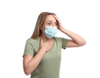 Young woman in medical mask suffering from pain during breathing on white background