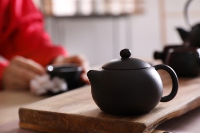 Traditional tea ceremony, focus on teapot. Guest enjoying beverage, closeup