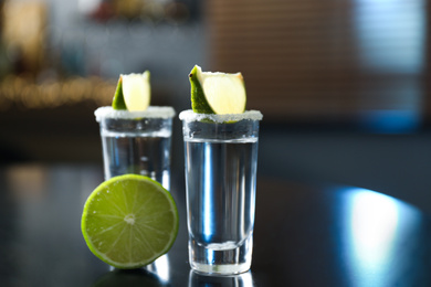 Mexican Tequila with salt and lime slices on black table at bar