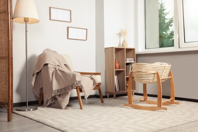 Photo of Stylish room with wooden furniture and cradle