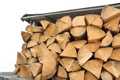 Pile of chopped firewood under roof outdoors