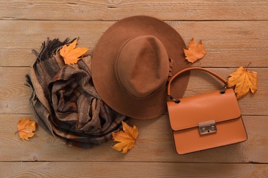 Photo of Flat lay composition with hat and dry leaves on wooden background. Autumn season