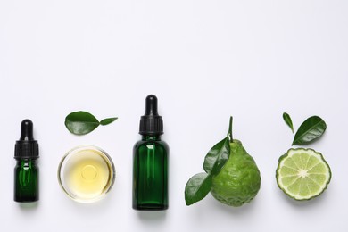 Bergamot essential oil and fresh fruits on white background, flat lay. Space for text