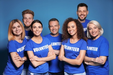 Team of volunteers in uniform on blue background