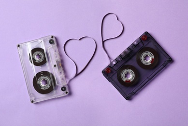 Music cassettes and hearts made of tape on violet background, flat lay. Listening love songs