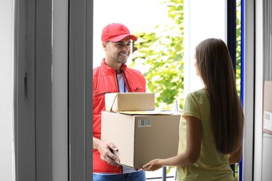 Woman receiving parcels from courier on doorstep