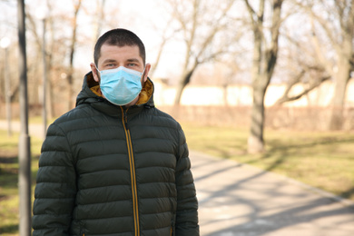Man wearing disposable mask outdoors. Dangerous virus
