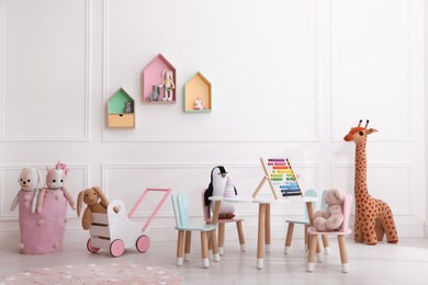 Photo of Cute child's playroom with toys and modern furniture. Interior design