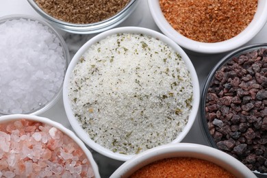 Different kinds of salt on white table, flat lay