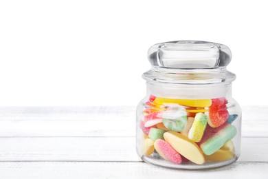 Tasty jelly candies in jar on white wooden table