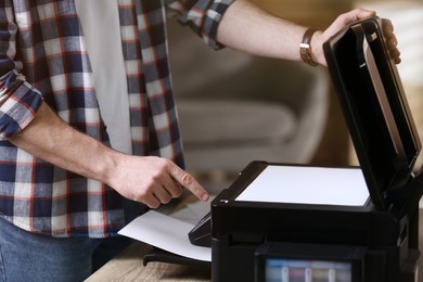 Man using modern multifunction printer in office, closeup