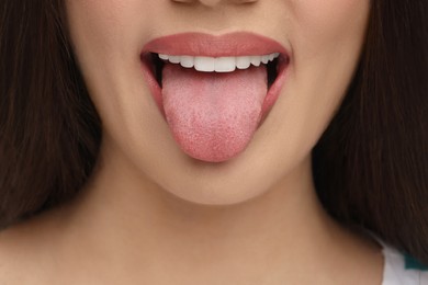 Photo of Woman with nude lipstick showing her tongue, closeup