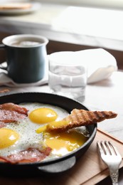 Tasty fried eggs with bacon and toast on table, closeup