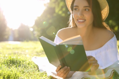 Photo of Beautiful young woman reading book in park