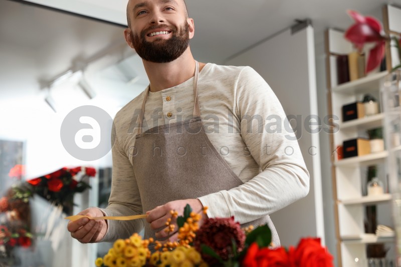 Professional male florist in apron at workplace