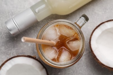 Photo of Mason jar of delicious iced coffee with coconut syrup on light grey table, flat lay