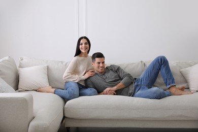 Couple resting on sofa in living room