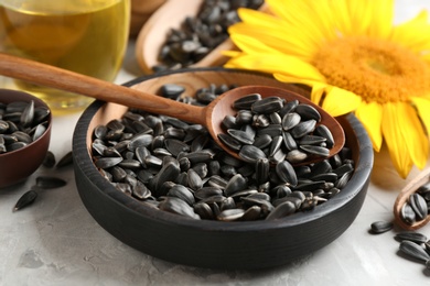 Bowl and spoon with sunflower seeds on table