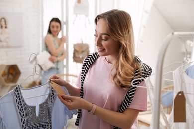 Woman choosing dress to buy in showroom
