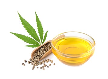 Bowl of hemp oil, fresh leaf and seeds on white background
