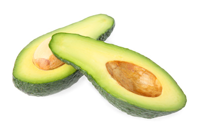 Cut tasty ripe avocados on white background. Tropical fruit