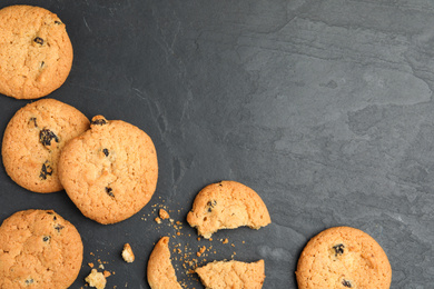 Delicious cookies with raisins on black table, flat lay. Space for text
