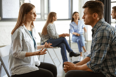 Psychotherapist working with patient in group therapy session indoors