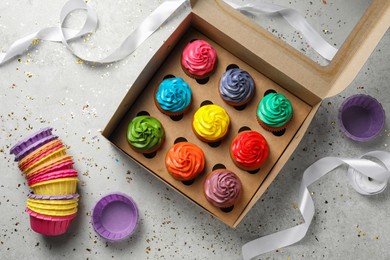 Flat lay composition with delicious colorful cupcakes on light grey table