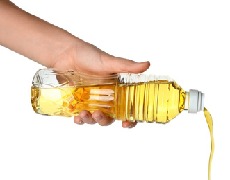 Woman pouring cooking oil from bottle on white background, closeup