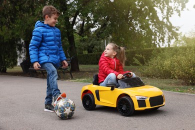 Cute little children with toy car and soccer ball having fun outdoors