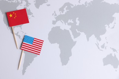 American and Chinese flags on world map, top view with space for text. Trade war concept