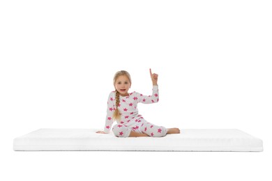 Photo of Little girl sitting on mattress against white background