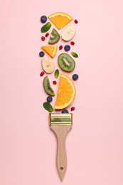 Creative flat lay composition with paint brush, fruits and berries on beige background