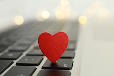 Decorative heart on laptop keyboard, closeup. Online dating concept