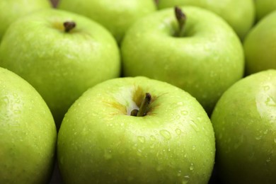 Delicious ripe green apples with water drops as background, closeup