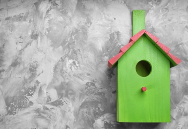 Beautiful green bird house on light grey background, space for text