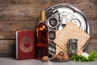 Symbolic Passover (Pesach) items on table against wooden background